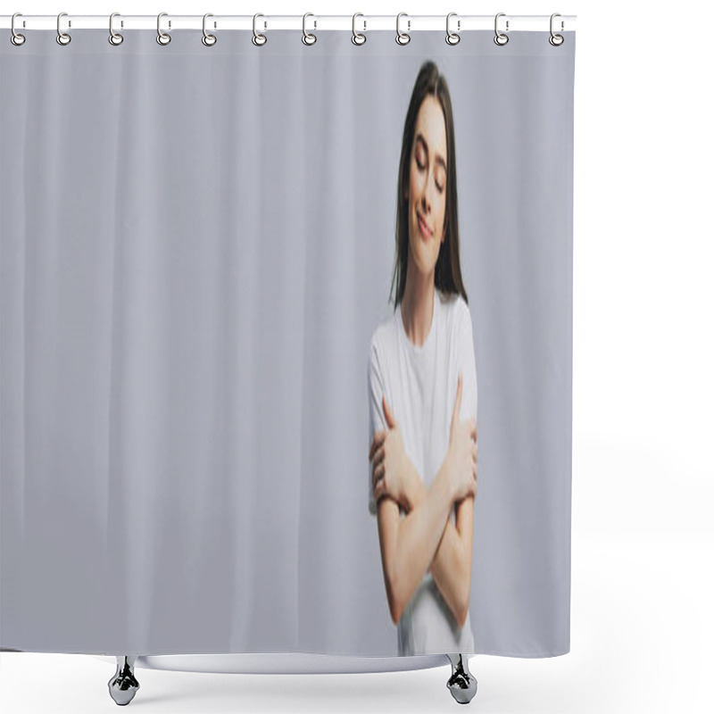 Personality  dreamy smiling beautiful girl in white t-shirt hugging herself with closed eyes isolated on grey, panoramic shot shower curtains