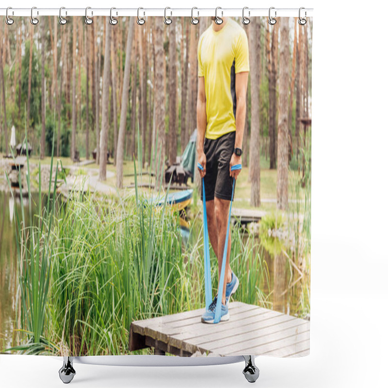 Personality  cropped view of sportsman working out with suspension straps near lake  shower curtains
