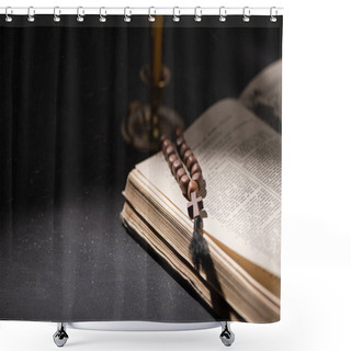 Personality  KYIV, UKRAINE - JANUARY 17, 2020: Selective Focus Of Candlestick Near Bible With Catholic Rosary In Dark With Sunlight Shower Curtains