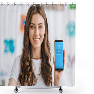 Personality  KYIV, UKRAINE - APRIL 17, 2019: Happy Smiling Girl Showing Smartphone With Skype App On Screen And Looking At Camera. Shower Curtains