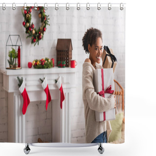 Personality  Cheerful African American Woman Holding Christmas Presents Near Blurred Fireplace At Home  Shower Curtains