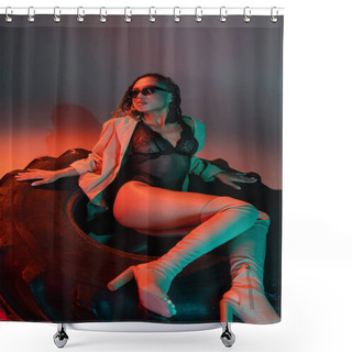Personality  Alluring And Sexy African American Woman In Fashionable Dark Sunglasses, Black Lace Bodysuit, Beige Trench Coat And Over Knee Boots Sitting On Huge Tire On Grey Background With Red Lighting Shower Curtains